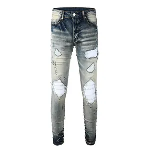 Detailed view of men's distressed slim jeans with vintage wash and white ribbed patches