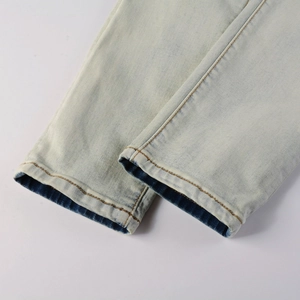 Macro view of light blue denim jeans hem with yellow double stitching detail