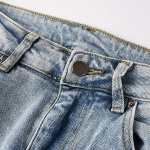 Détail de la taille du jean bleu clair avec bouton métal et double couture jaune