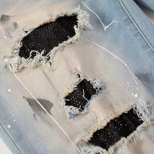 Detailed macro view of distressed denim jeans with sequins and black mesh patches
