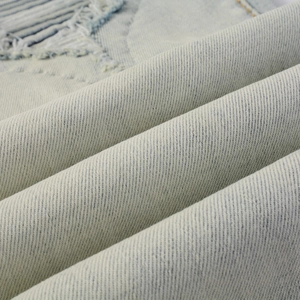 Macro shot of light blue washed denim fabric with retro distressed frayed details