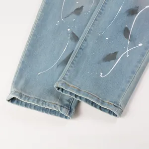 Detail of light blue denim jeans with artistic black and white splash ink graffiti print
