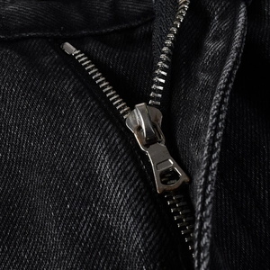 Macro shot of retro metal zipper and washed black denim fabric texture on vintage jeans