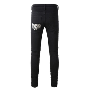 Men's slim fit black jeans featuring a unique leopard print patch on the back pocket
