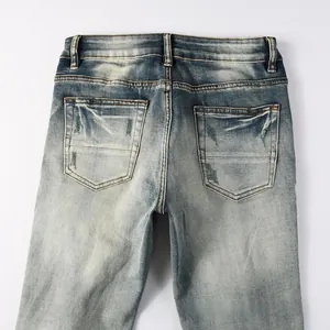 Detail of slim fit denim jeans back pockets featuring wash effect and distressed texture