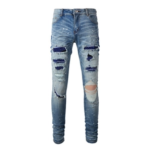 Slim fit light blue distressed jeans with sequin patches and white paint splatters