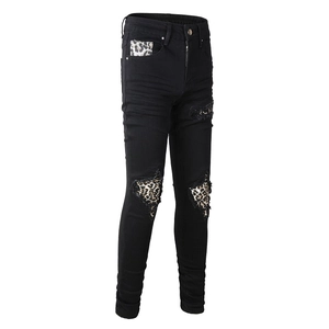 Detailed shot of men's slim black ripped jeans with stylish leopard print patchwork