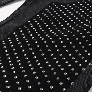 Close-up of black washed denim fabric featuring dense rhinestone matrix pattern