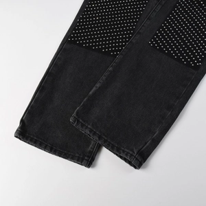 Close-up of sparkling rhinestone patterns on vintage black denim straight-leg jeans