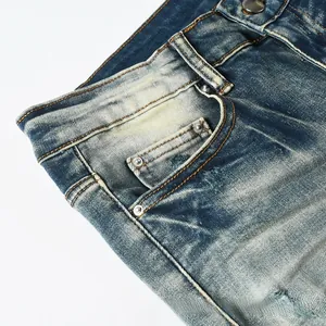 Detail of vintage blue washed denim jeans with metal rivets and contrast stitching
