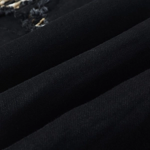 Macro shot of black denim fabric with distressed details and leopard print patchwork texture
