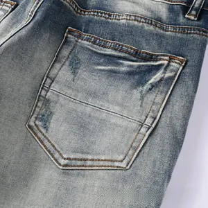 Close-up of distressed back pocket detail on vintage washed blue denim jeans