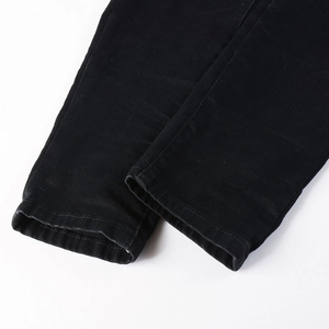 Close-up of black denim jeans hem showing high-quality stitching and fabric texture