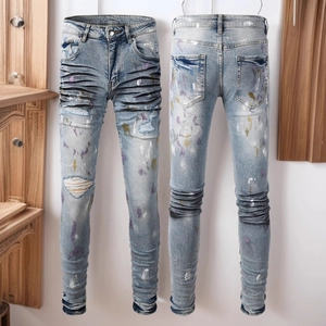 Jean bleu clair ajusté avec taches de peinture colorées et détails usés déchirés