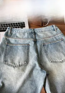 Detailed view of light blue washed denim shorts featuring back pocket and stitching details