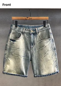 Detailed close-up of light wash denim shorts with vintage whiskering and cuffed hems