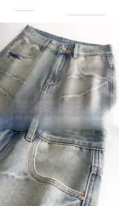 Detail view of washed light blue denim fabric with metal button and stitching details