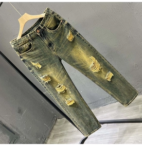 Close-up of distressed ripped details and vintage acid wash on light denim jeans