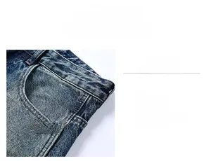 Detailed macro view of denim jeans featuring slanted pockets and orange contrast stitching