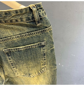 Detail of vintage washed denim jeans showing rear pockets and sturdy double stitching