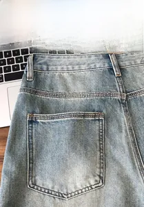 Detail of light blue washed denim shorts showing back pocket with double-needle stitching