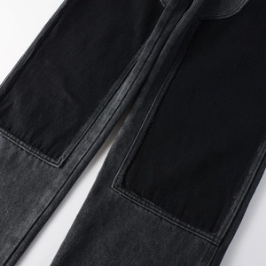 Detail of dark washed denim jeans with vintage black patchwork and twill texture