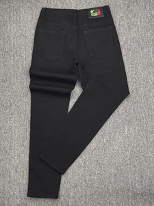 Close-up of the black denim jeans back waist featuring a premium leather brand patch