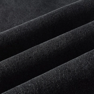 Detailed macro view of dark grey distressed denim fabric texture and twill weave