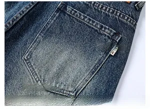 Detail of reinforced back pocket stitching on vintage blue distressed denim jeans