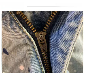 Detailed macro shot of vintage bronze YKK metal zipper on washed denim shorts