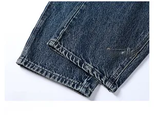 Detailed close-up of dark blue washed denim jeans with durable double-stitch seam hem