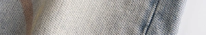 Macro shot of high-quality cotton denim fabric showing detailed blue and white twill texture