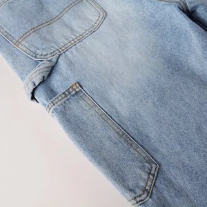 Detailed macro view of light blue denim fabric with orange stitching and cargo pocket