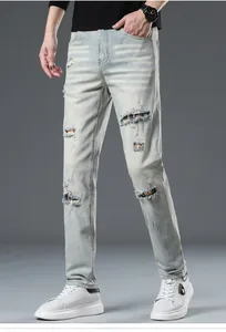 Detailed close-up of distressed light blue denim jeans with stylish plaid fabric patches