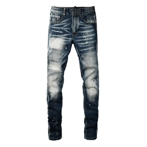 Slim fit distressed blue jeans with vintage graffiti paint splatters and whiskers