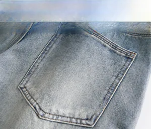 Macro detail of blue washed denim fabric texture and double-stitched back pocket seam
