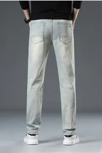 Detail view of men's slim fit light blue washed denim jeans with back pocket stitching