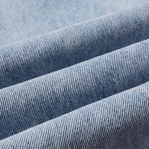 Macro shot of light blue cotton denim fabric showing twill weave and washed texture