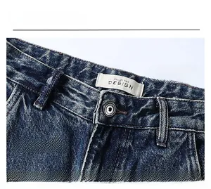 Close-up of waistband on light blue washed denim jeans with silver button and quality stitching
