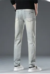 Detail view of light blue distressed jeans with slim fit back pocket design
