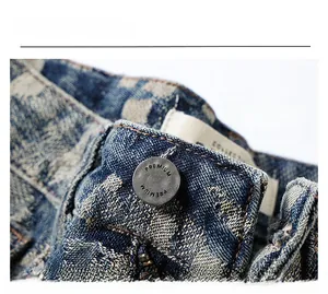 Close-up of premium metal button and texture on light blue distressed denim jeans