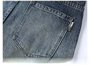 Detail of reinforced rear pocket on slim fit washed denim jeans with small brand tag