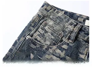 Detail of vintage blue denim jeans side pocket with metal rivets and coin pocket design