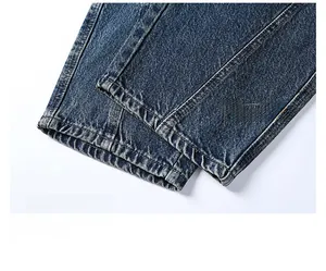 Close-up of double-stitched hem on vintage washed slim fit denim jeans with twill texture