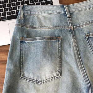 Vintage light blue washed denim shorts with high-quality stitching on a wooden surface