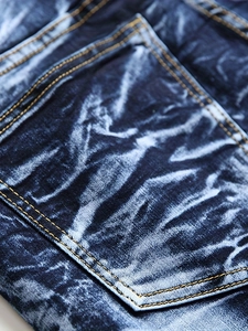 Gros plan détaillé du tissu denim délavé bleu foncé avec doubles coutures orange
