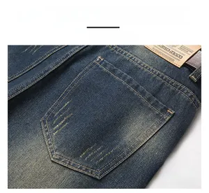Detailed view of dark blue denim rear pocket with vintage wash and leather brand tag