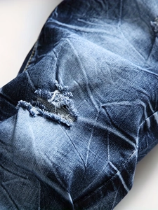 Vue macro du denim bleu foncé usé avec détails de déchirures et effets de délavage