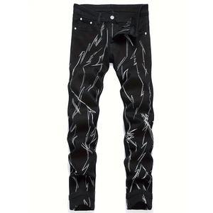 Détail d'un jean slim noir avec des broderies blanches en forme d'éclairs et de poches