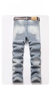Flat lay of vintage ripped jeans back view with brown leather belt and fashion label